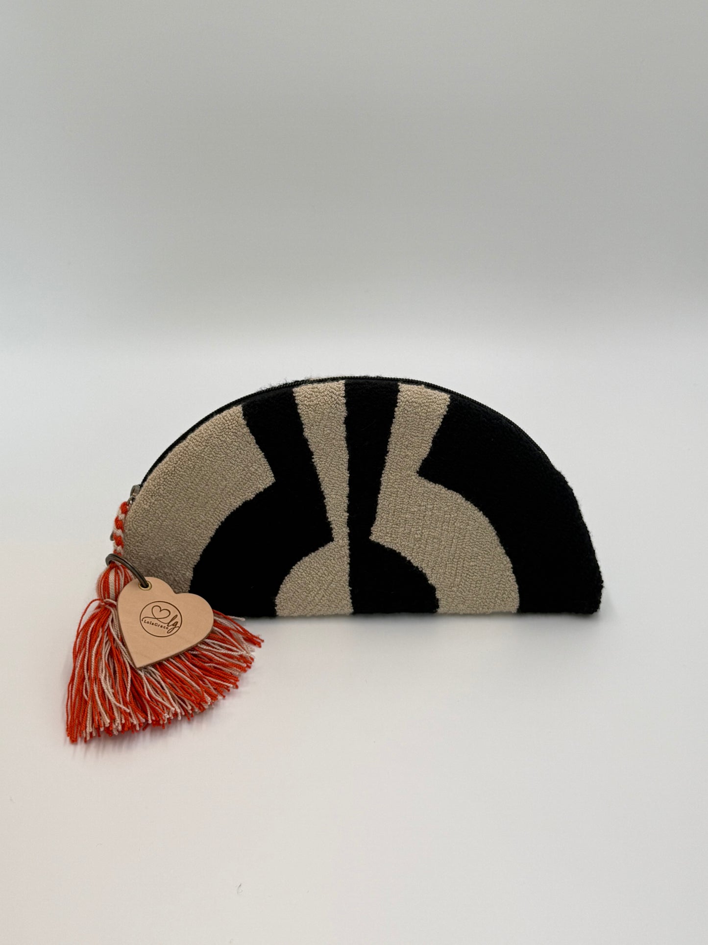 Achterzijde van de Wayuu clutch Aura met krachtig grafisch design in zwart en crème
