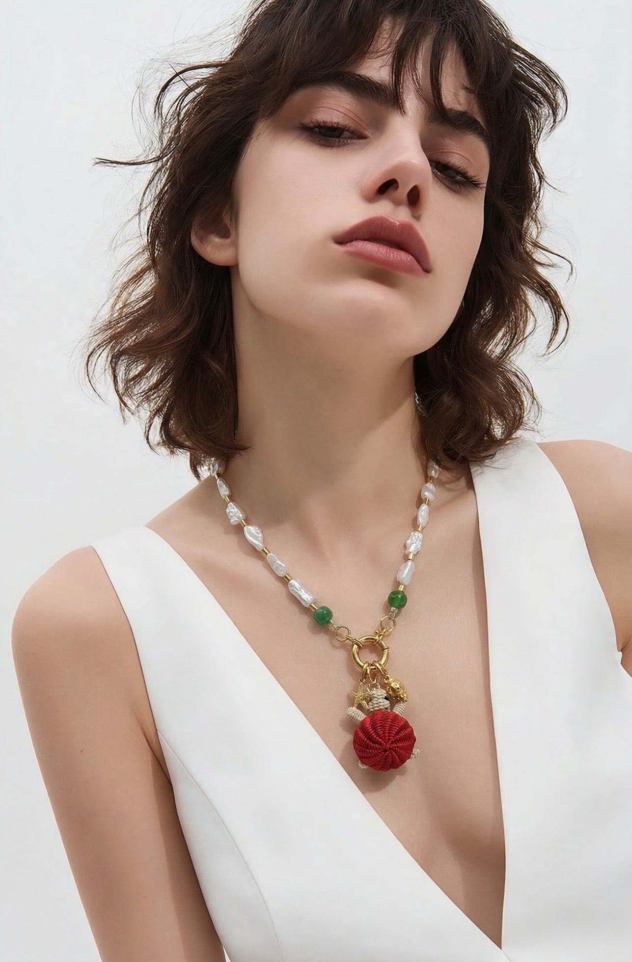 Handgemaakte ketting met natuurparels en groene jade met 24 karaat vergulde accenten en schildpadbedel van Werregue-palm gedragen door model