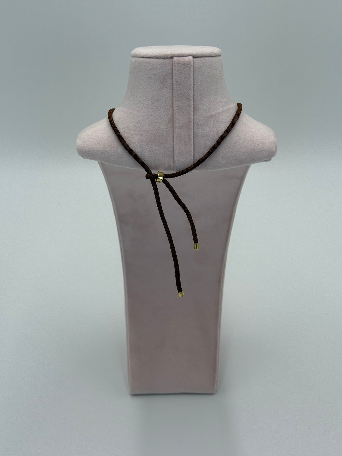 Achterkant van handgemaakte nylon ketting met verstelbare sluiting en 24 karaat vergulde details
