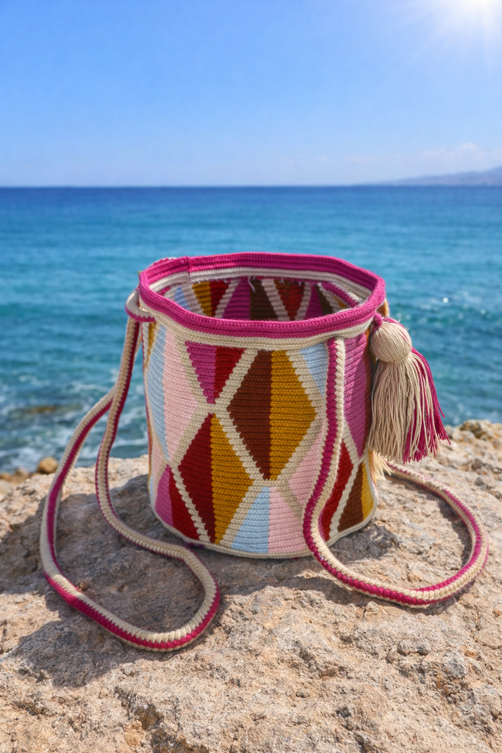 Kleurrijke Wayuu tas Ines Medium van LolaGrace aan zee, handgemaakte bohemian schoudertas geïnspireerd door traditioneel Colombiaans vakmanschap.