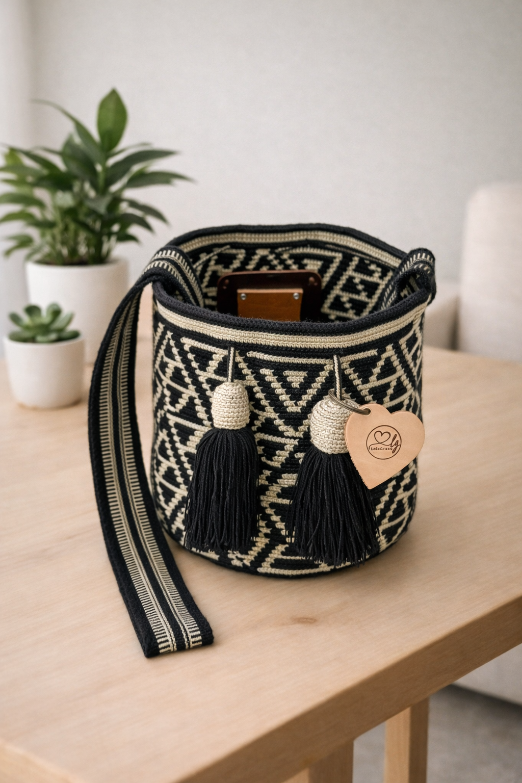 Yurany medium Wayuu mochila tas van LolaGrace handgemaakt in Colombia met zwart-wit geometrisch patroon op houten tafel in lichte interieursetting