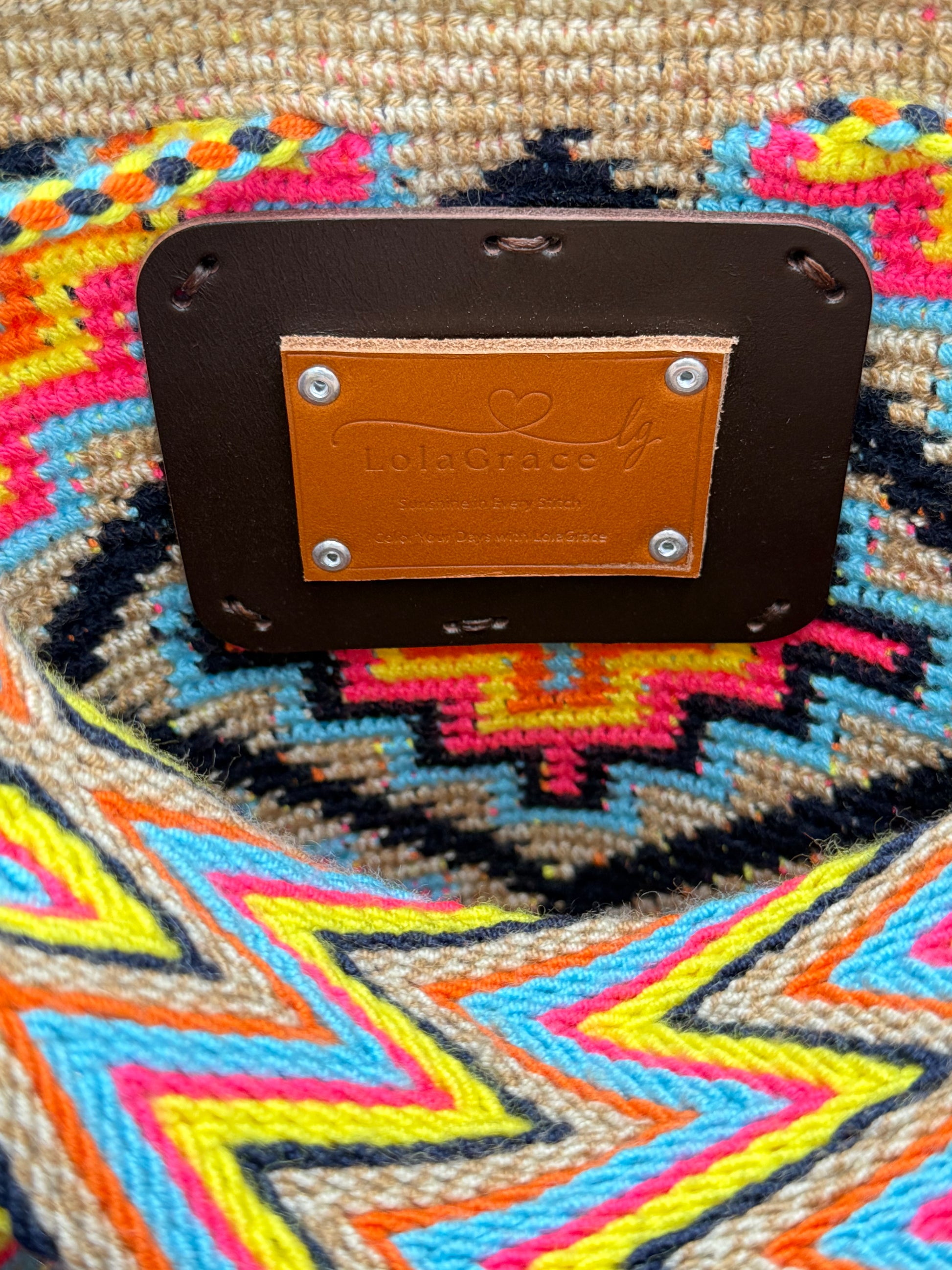 Detail van het lederen LolaGrace label aan de binnenkant van een handgemaakte Wayuu mochila tas uit La Guajira, Colombia.