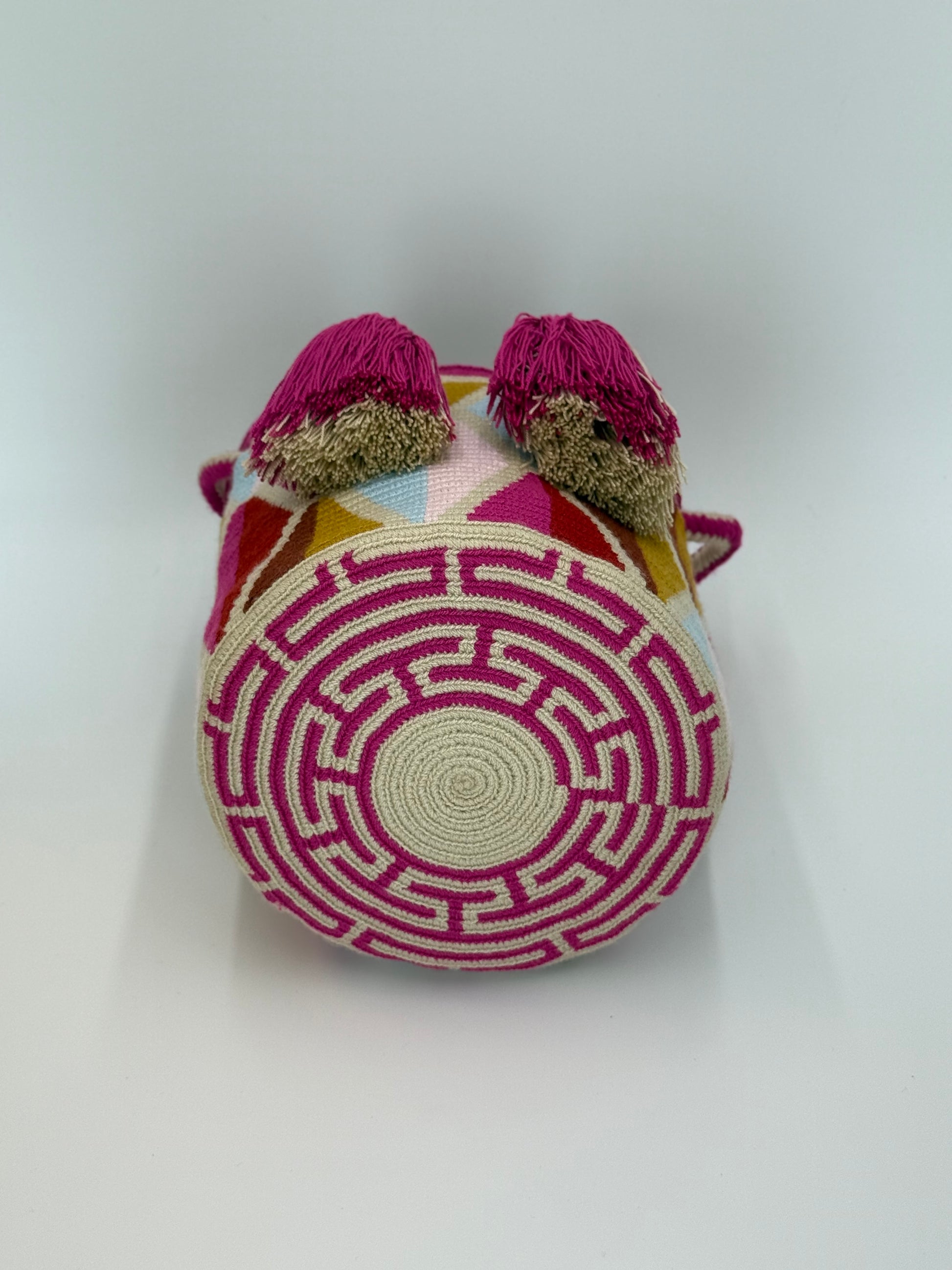 Onderkant van handgemaakte Wayuu tas Ines Medium van LolaGrace met rond traditioneel weefpatroon in crème en fuchsia roze, ambachtelijk gemaakt door Wayuu-artisans uit Colombia.