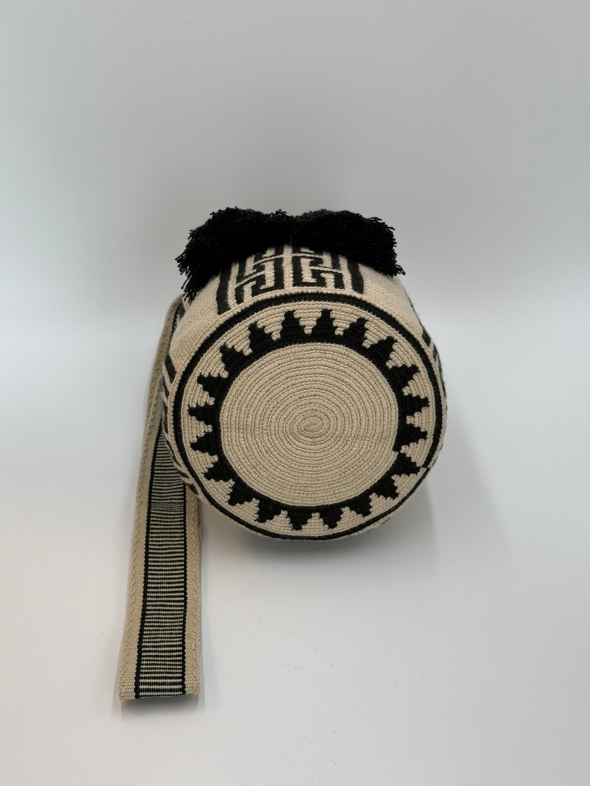 Ronde bodem van Angie Medium Wayuu mochila tas van LolaGrace, handgemaakt in Colombia met crème en zwart geweven patroon.