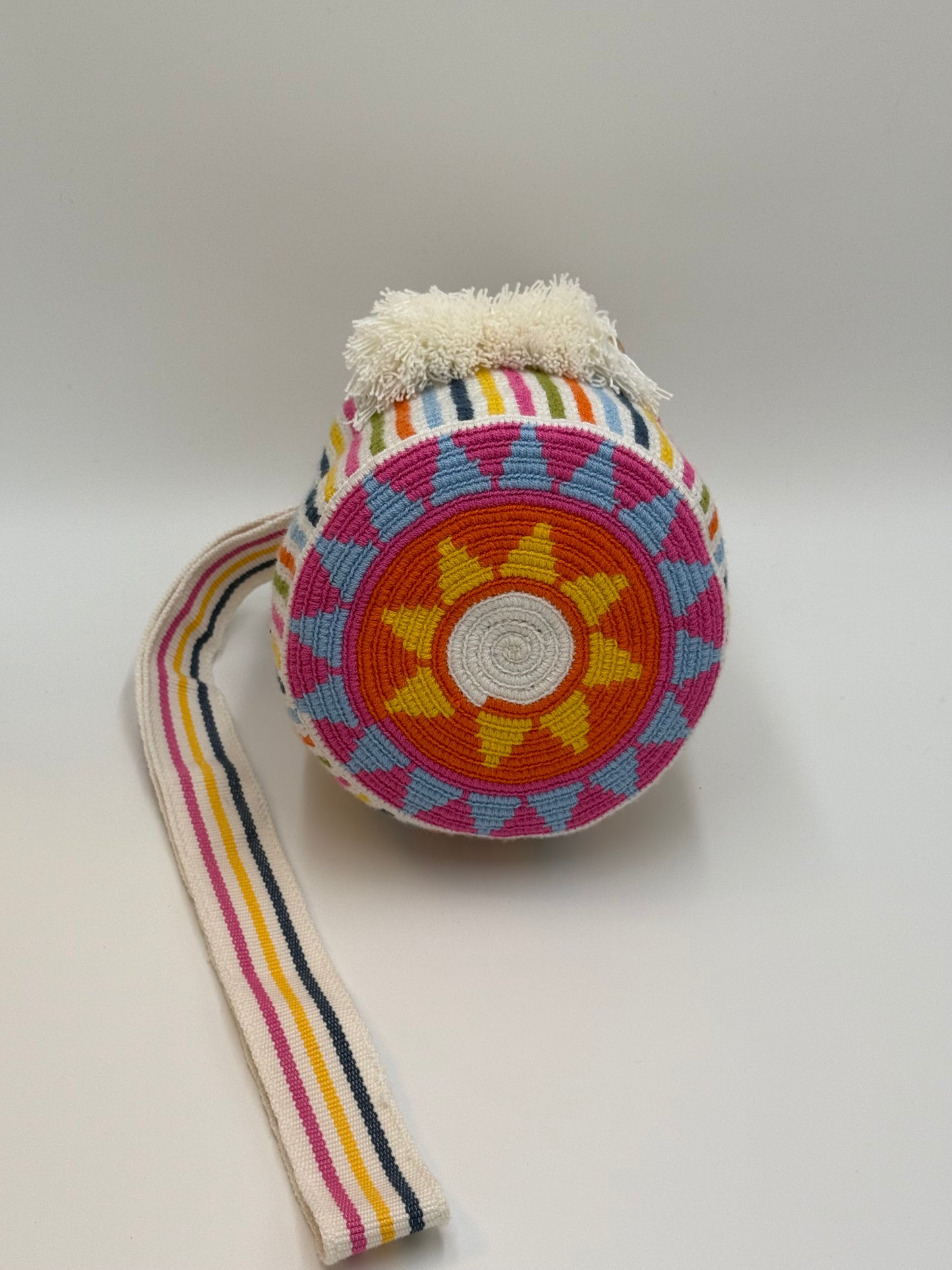 Onderkant van handgemaakte Wayuu tas Catalina Sofia Medium van LolaGrace met rond traditioneel Wayuu patroon in oranje, roze, geel en lichtblauw.