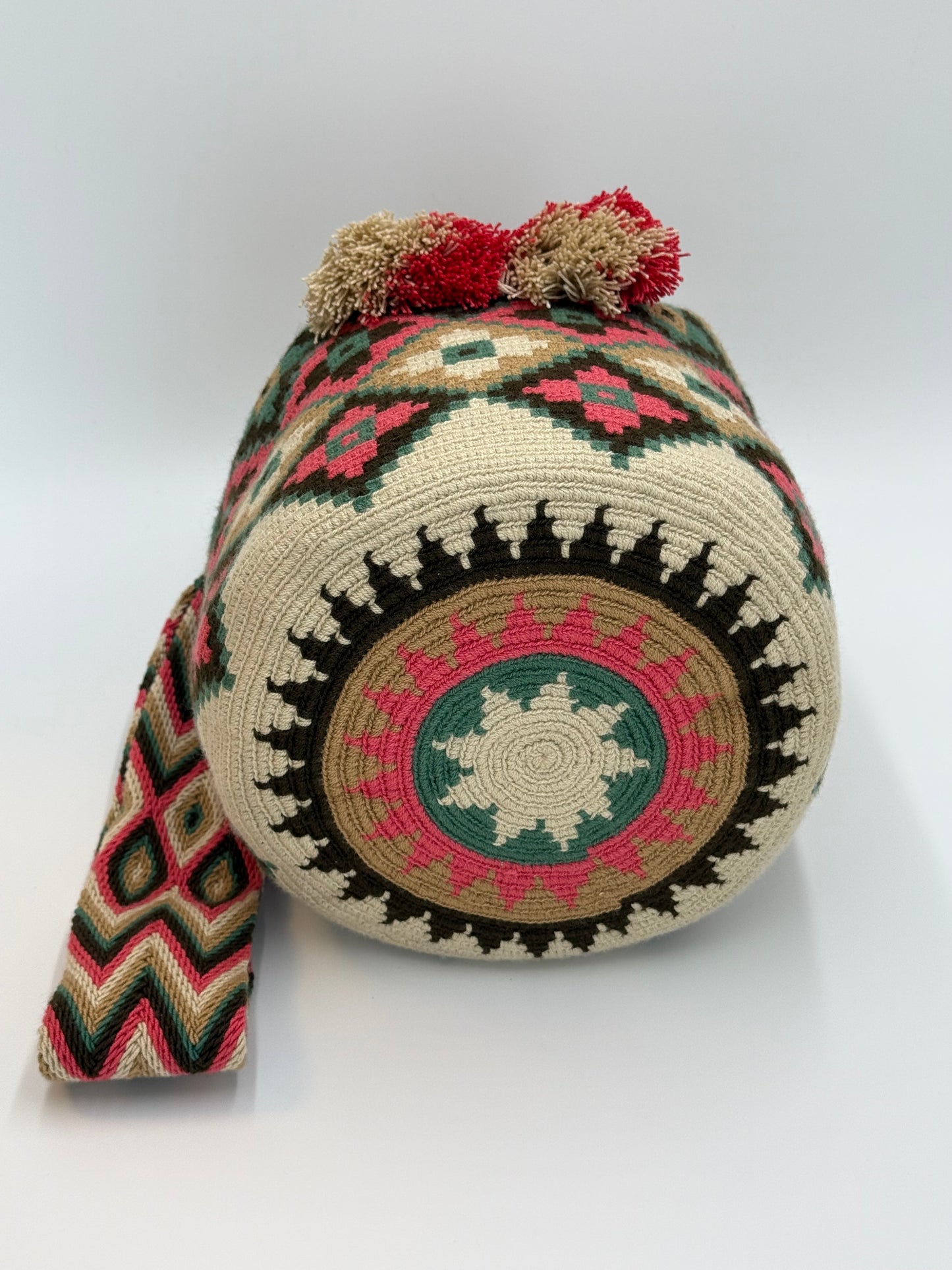 Onderkant van handgemaakte Wayuu tas Claudia Large van LolaGrace met traditioneel rond Wayuu weefpatroon in crème, groen, bruin en roze.