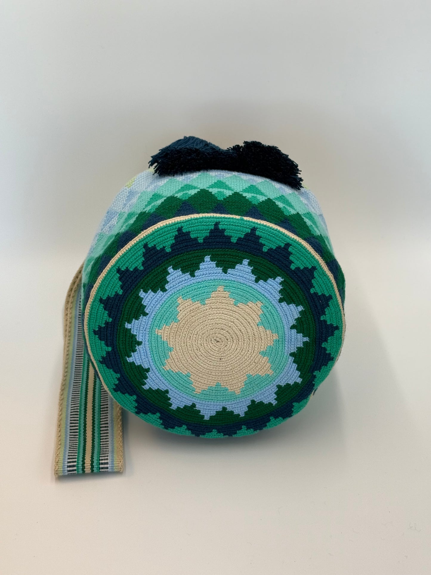 Onderkant van Danna large Wayuu mochila tas van LolaGrace handgemaakt in Colombia met rond geometrisch patroon in groen, blauw en beige