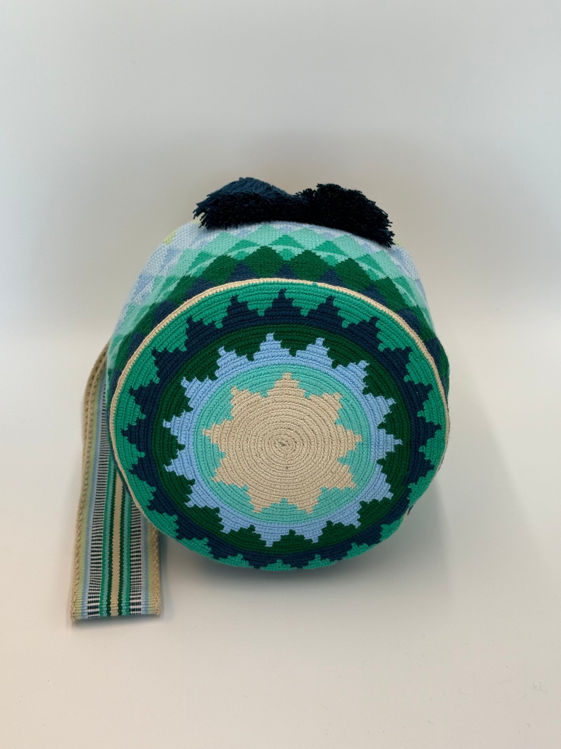 Onderkant van Danna large Wayuu mochila tas van LolaGrace handgemaakt in Colombia met rond geometrisch patroon in groen, blauw en beige