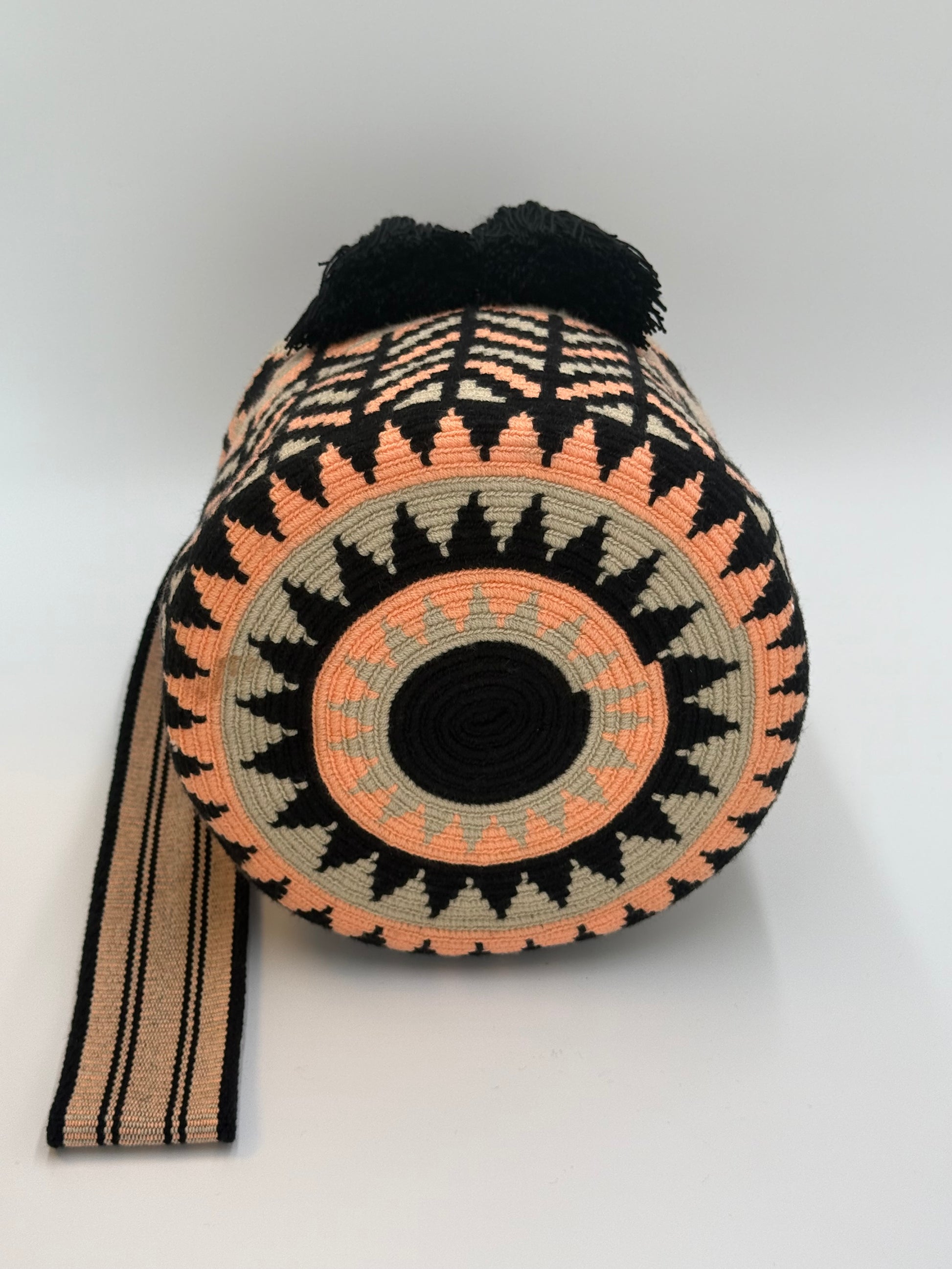 Ronde bodem van Karen Large Wayuu mochila tas van LolaGrace, handgemaakt in Colombia met zwart, perzik en crème geometrisch patroon.