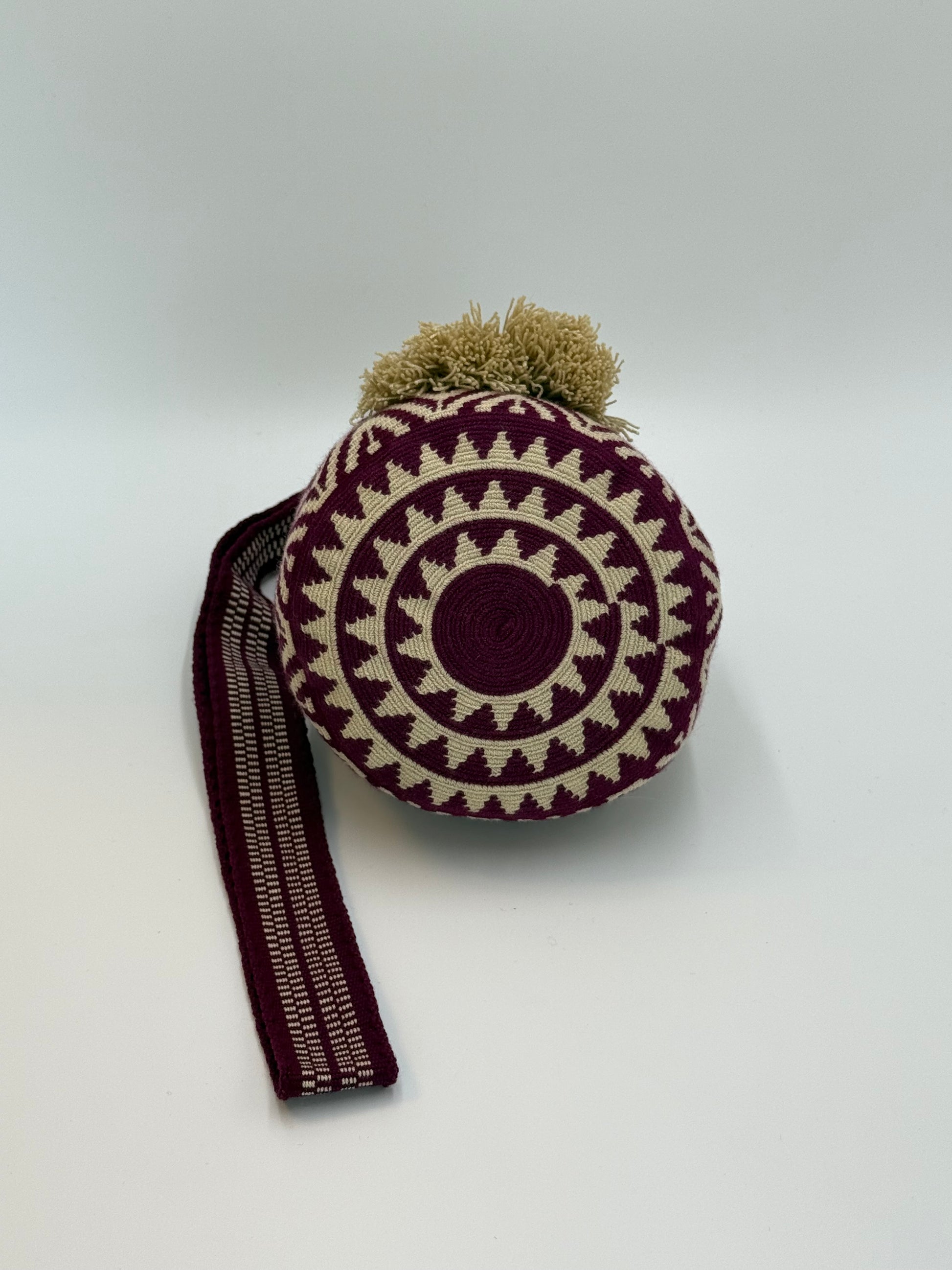 Detail van de ronde bodem van Wayuu tas Rosa Maria met een harmonieus patroon in diep bordeaux en crème tinten