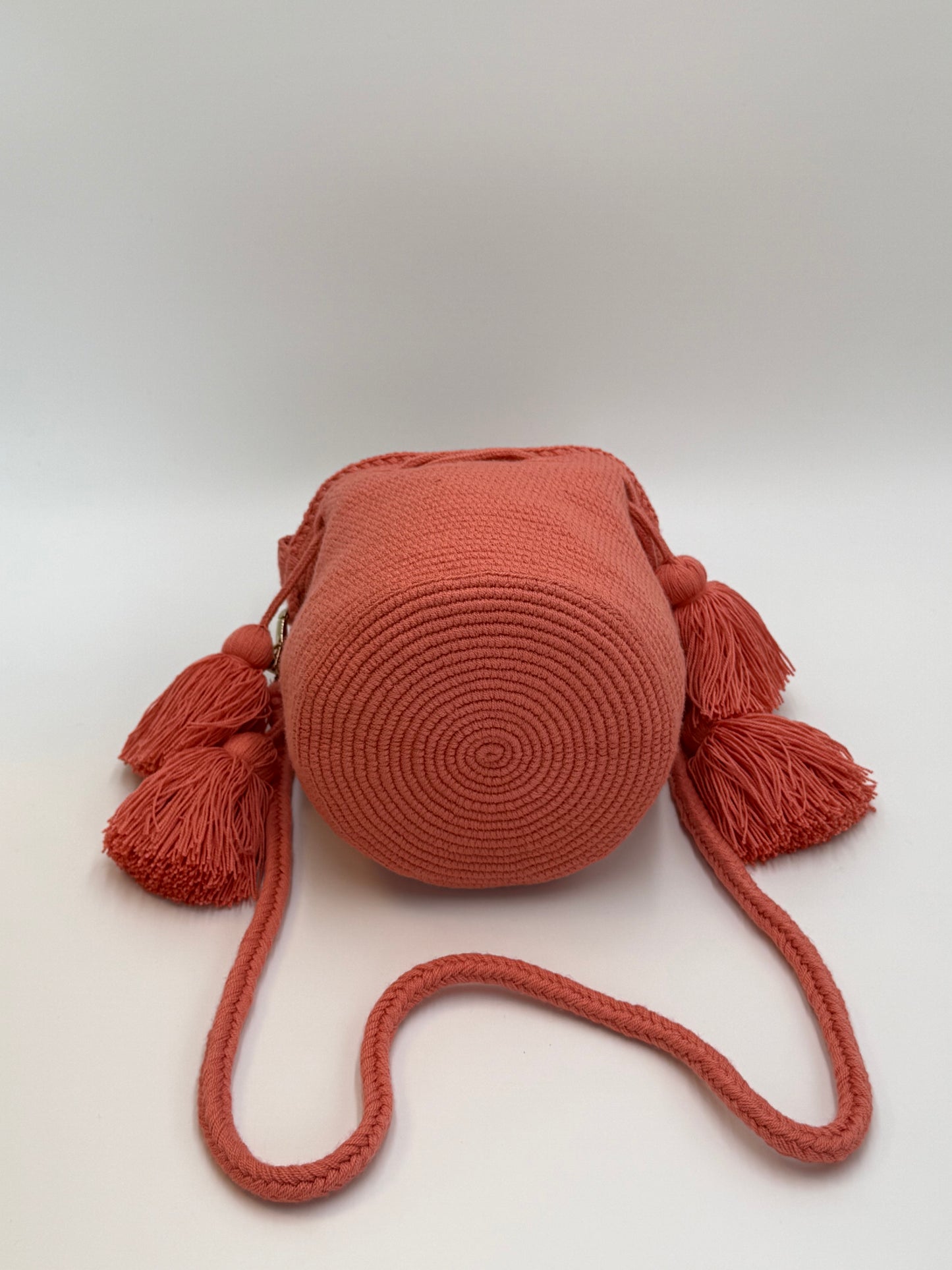 Ronde bodem van Wayuu tas Xiomara in koraal met verfijnd spiraalpatroon