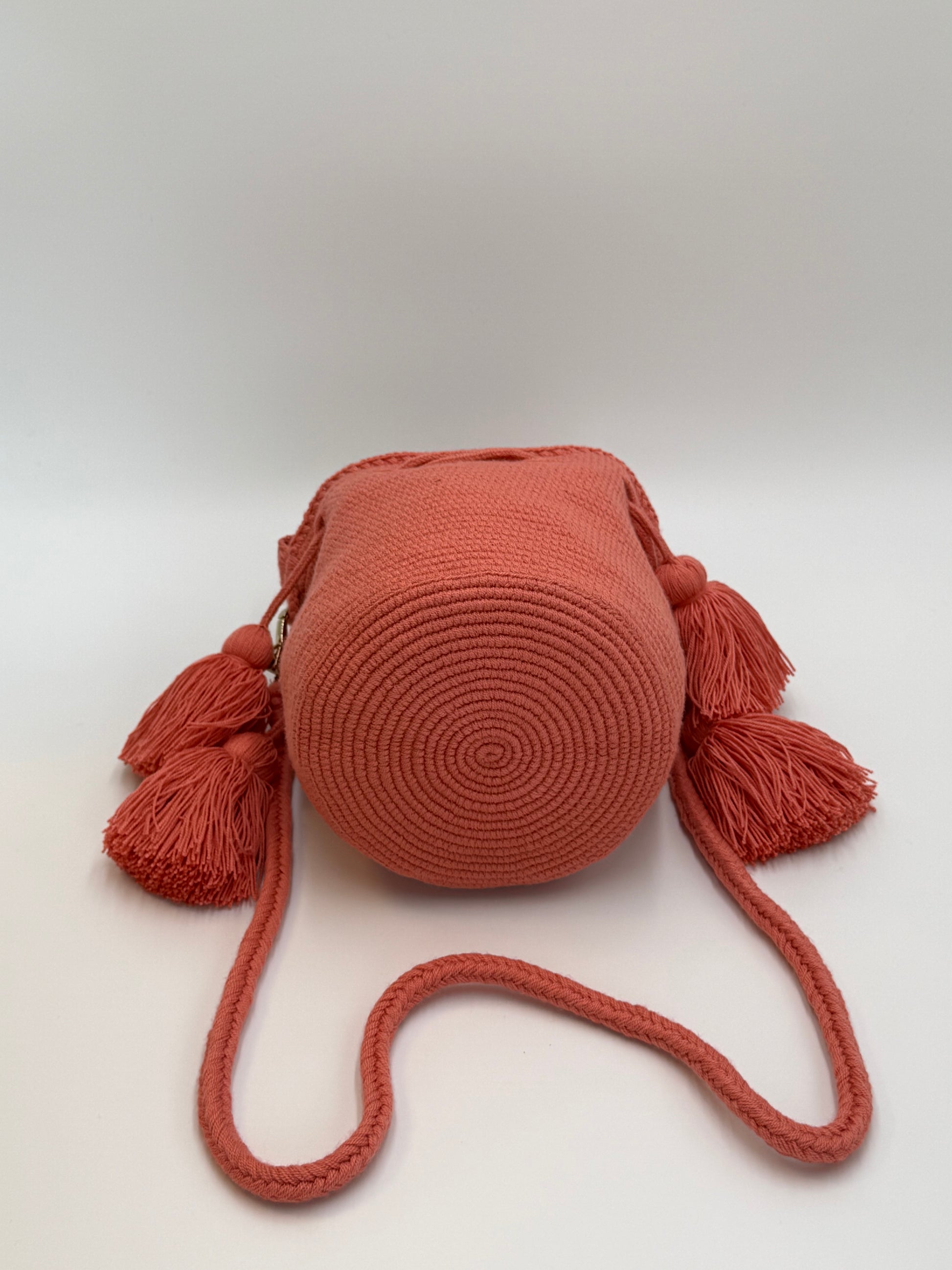 Ronde bodem van Wayuu tas Xiomara in koraal met verfijnd spiraalpatroon