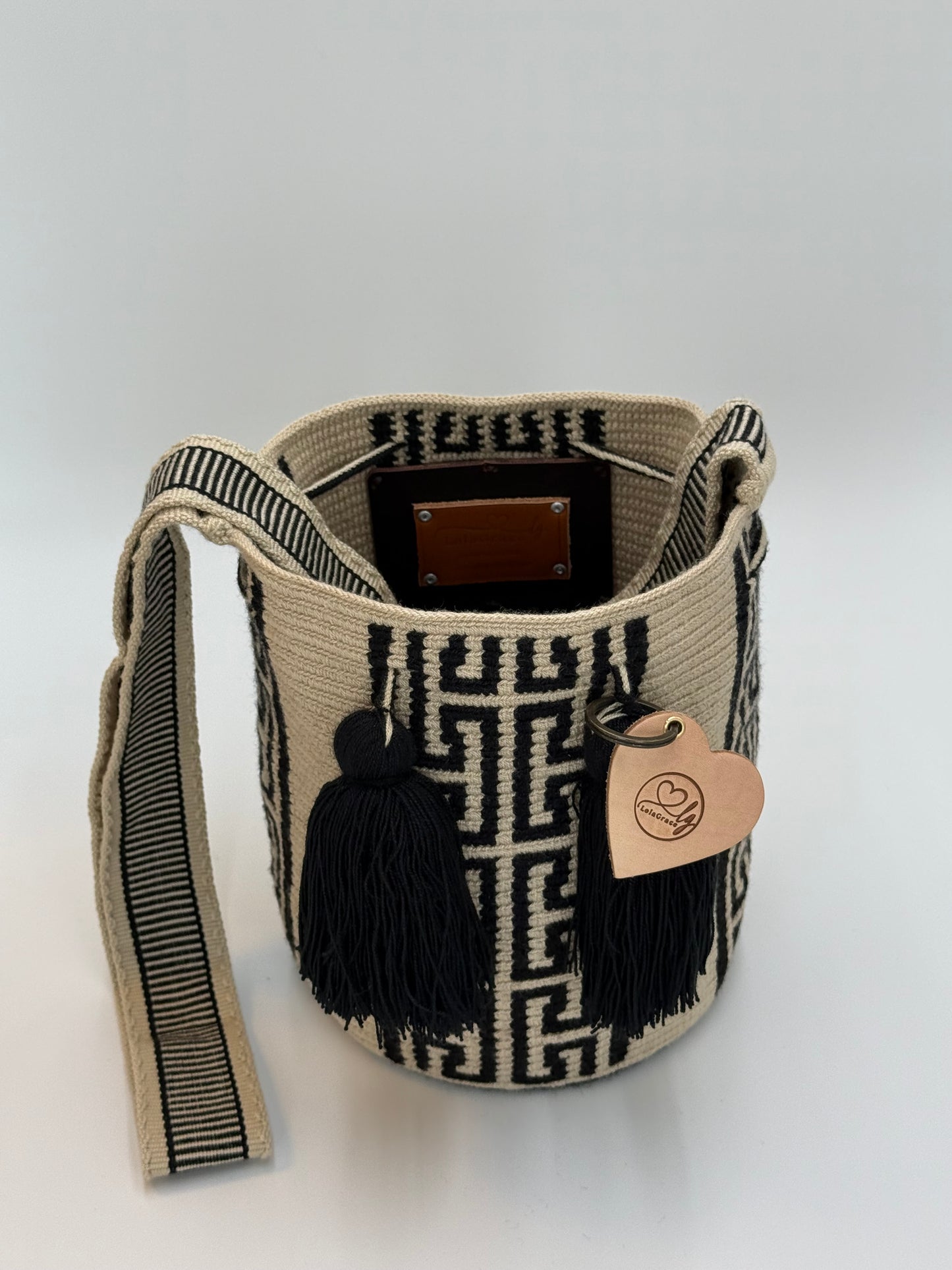 Open Angie Medium Wayuu mochila tas van LolaGrace, handgemaakt in Colombia met crème en zwart geometrisch patroon en zwarte kwasten.
