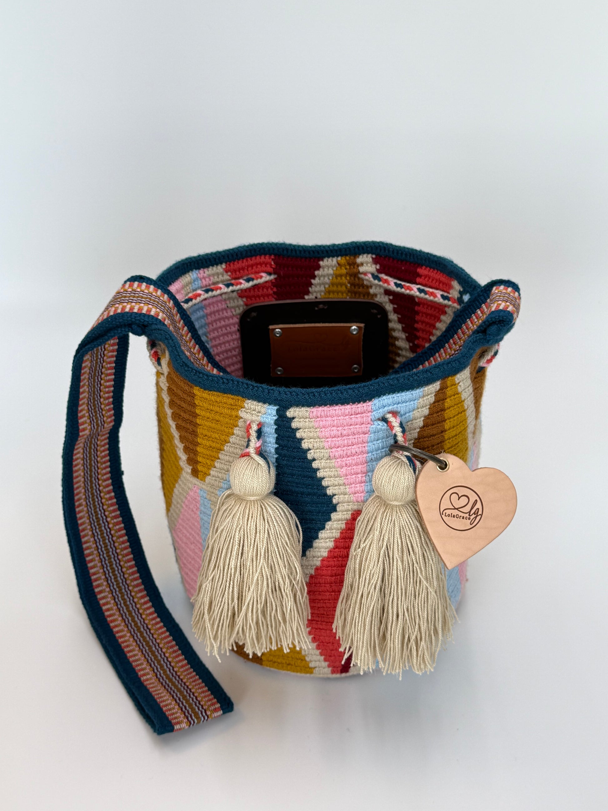 Open handgemaakte Wayuu tas Carmen Medium van LolaGrace met blauw geweven schouderband, geometrisch patroon en crème kwastjes.