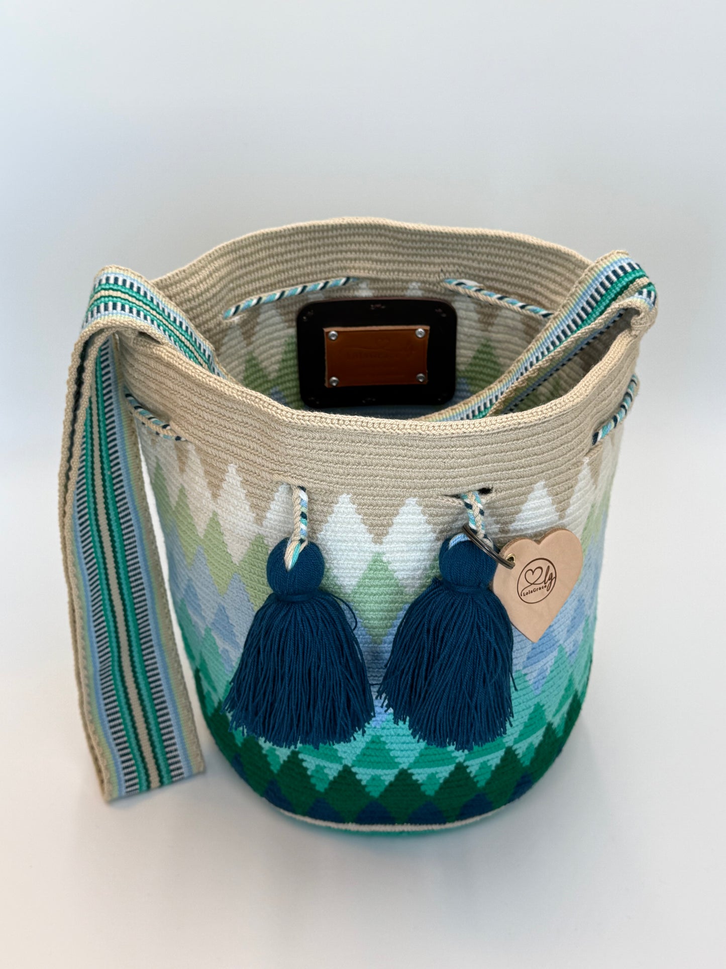 Danna large Wayuu mochila tas van LolaGrace handgemaakt in Colombia open met groen en blauw geometrisch patroon en donkerblauwe kwasten