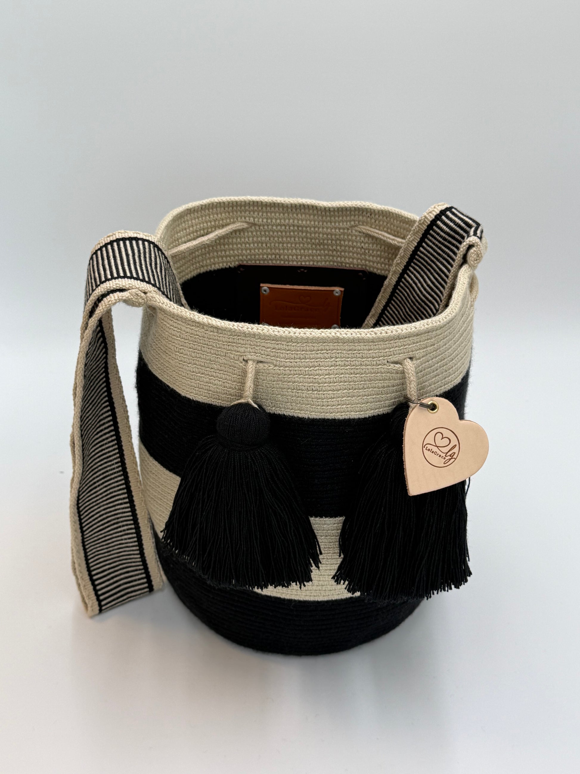 Open handgemaakte Wayuu tas Isabela Large van LolaGrace in zwart en crème met zwarte kwastjes en brede geweven schouderband.