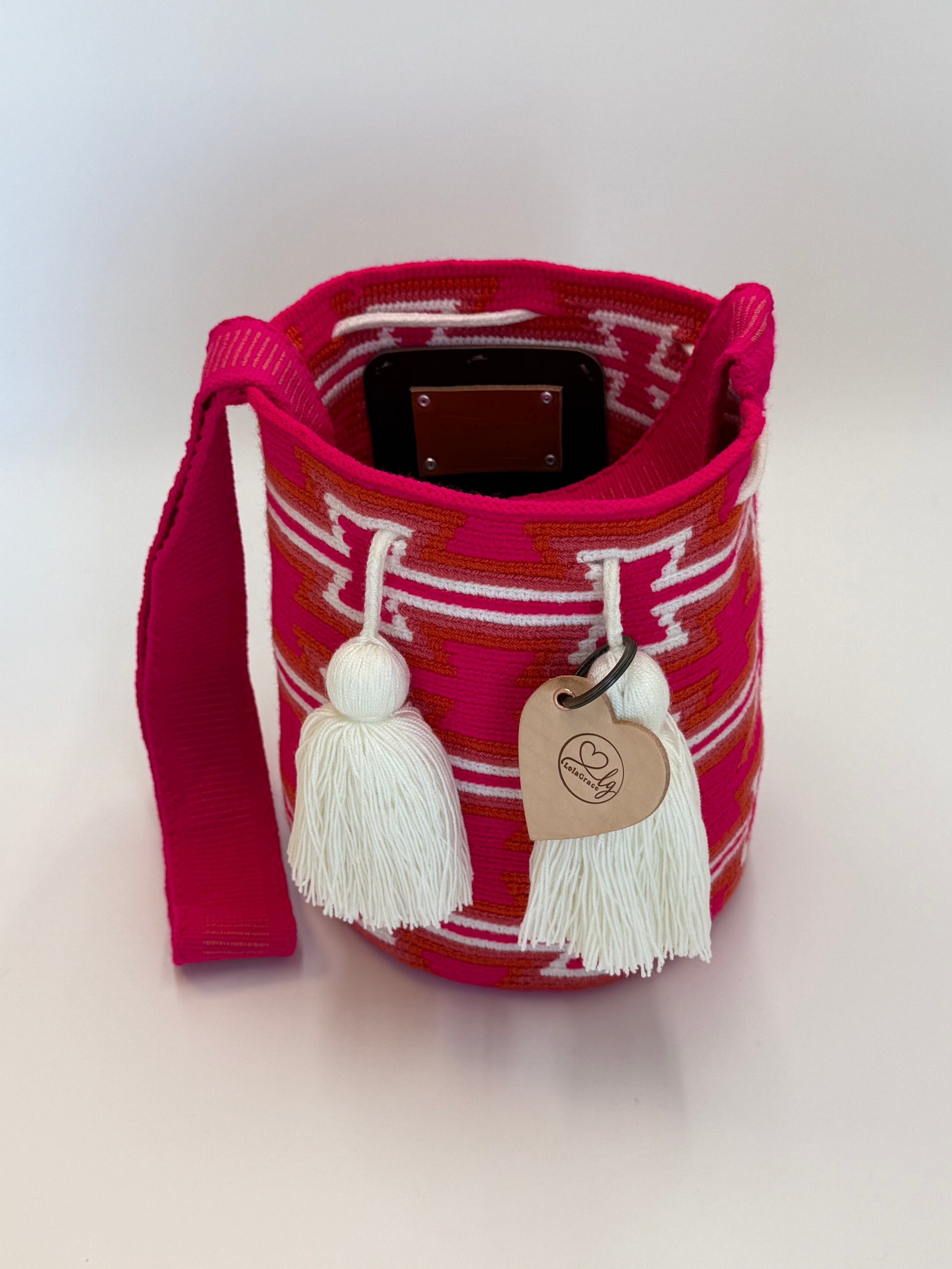 María Fernanda medium Wayuu tas van LolaGrace handgemaakt in Colombia open met fuchsia roze patroon en witte kwasten