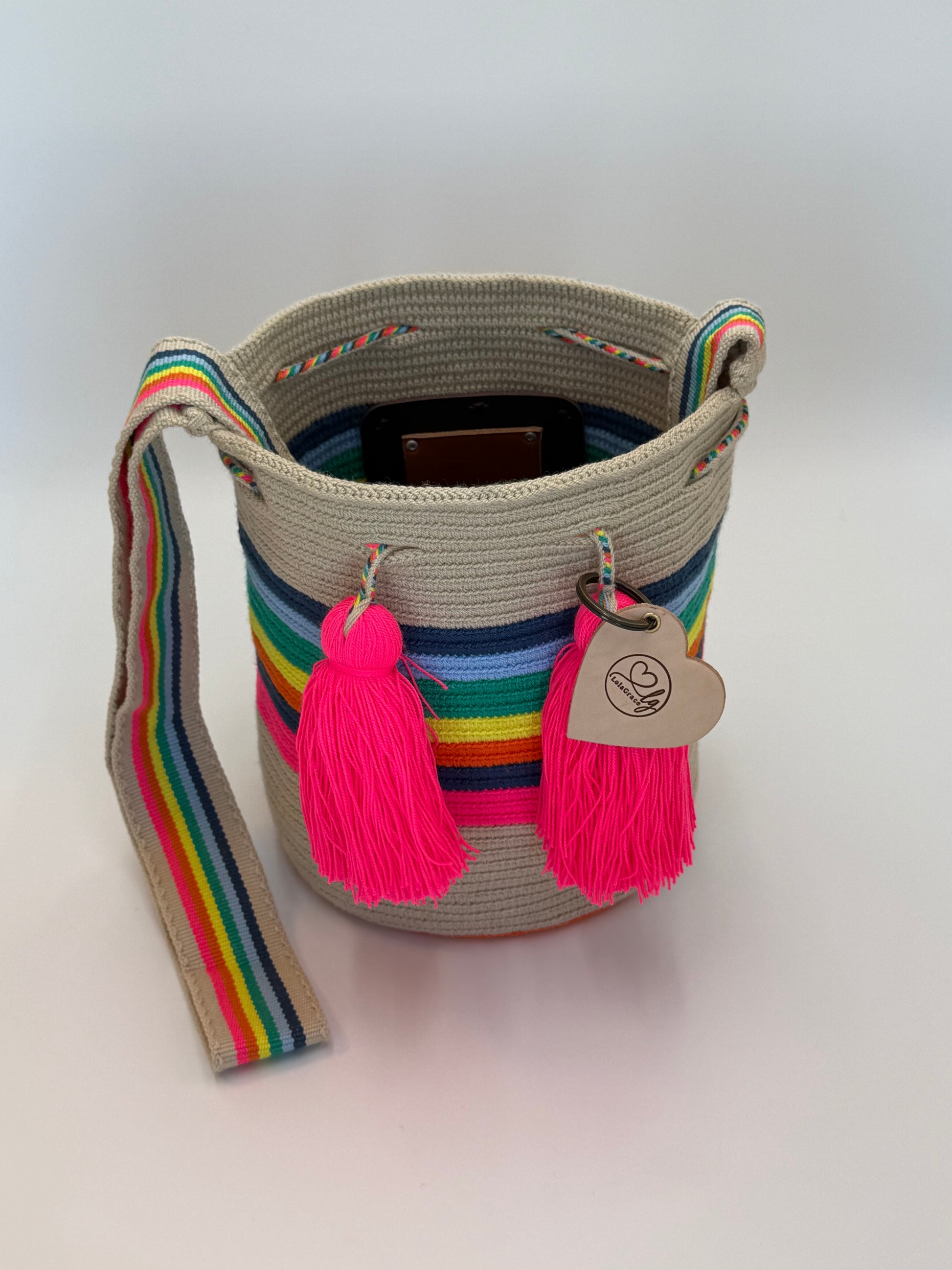 Sara Lucia medium Wayuu tas van LolaGrace handgemaakt in Colombia open met regenboog strepen en neon roze kwasten