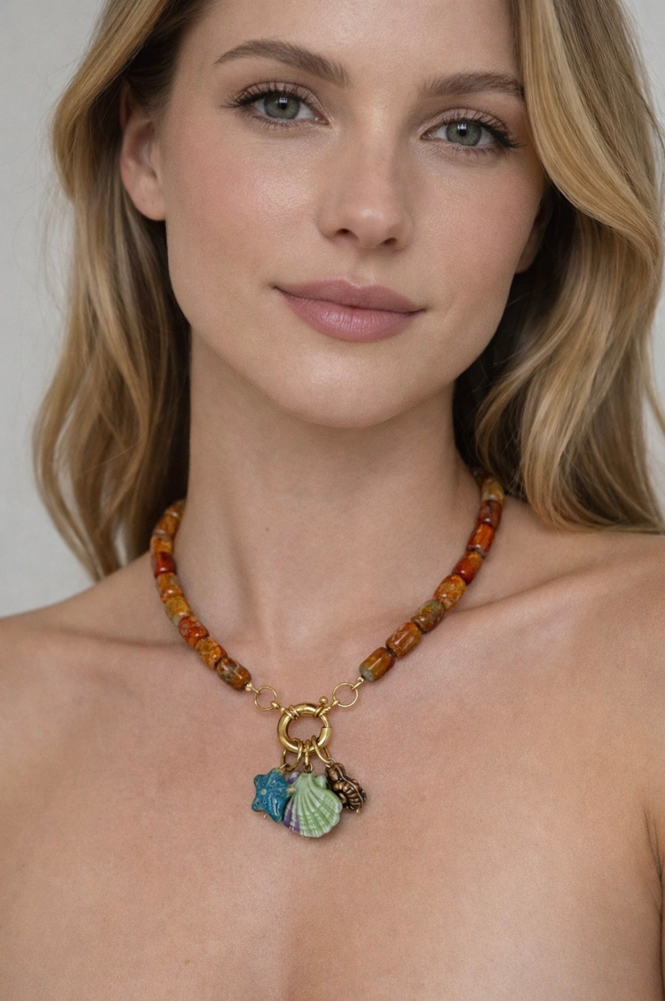 Handgemaakte ketting met Tamborera stone agaat en 24 karaat vergulde accenten met zeester- en schelpbedels, gedragen door model