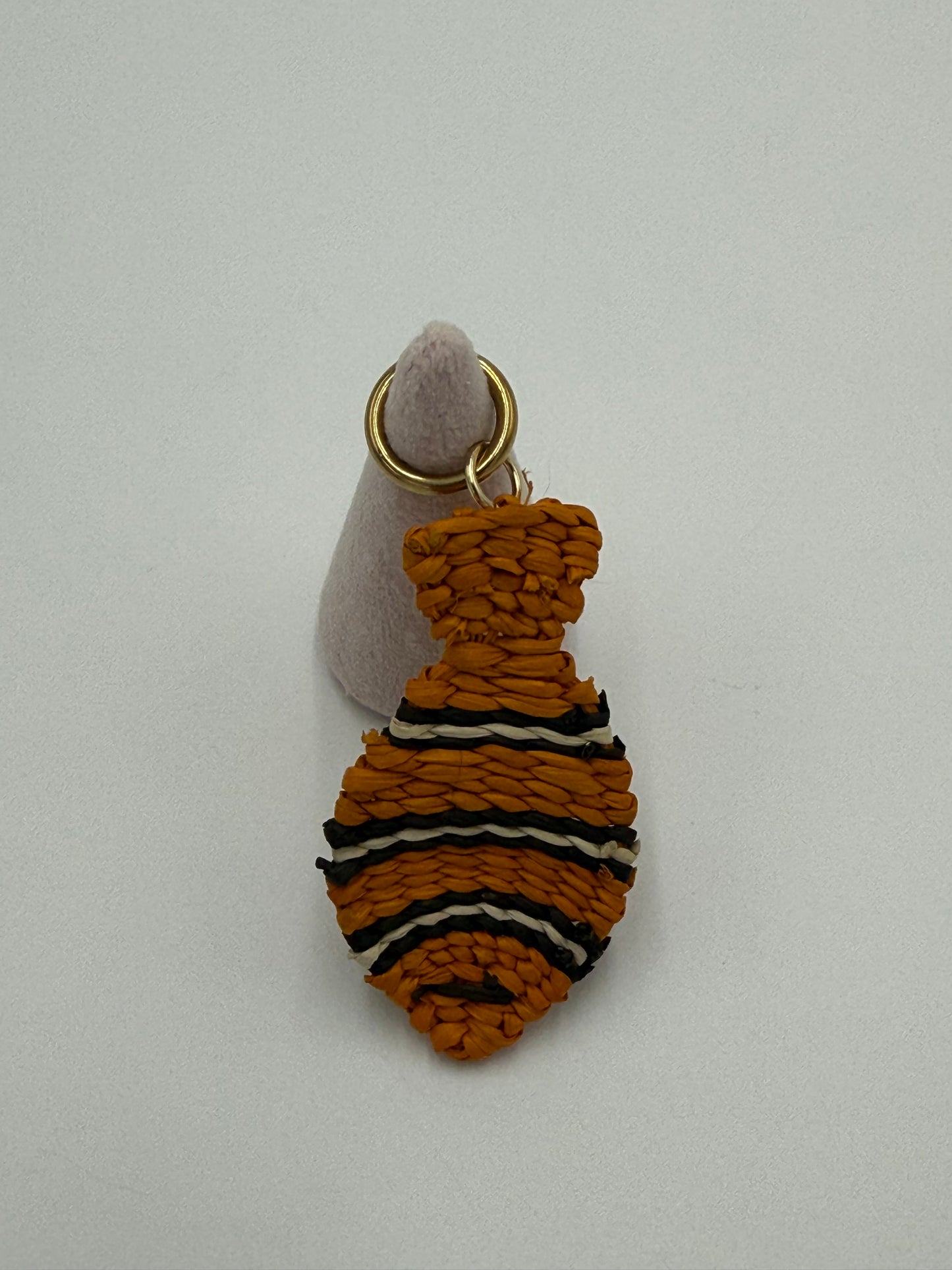 Handgemaakte vis kettingbedel van gevlochten Werregué-palm in oranje met zwarte en witte accenten en bronzen ring verguld met 24 karaat goud