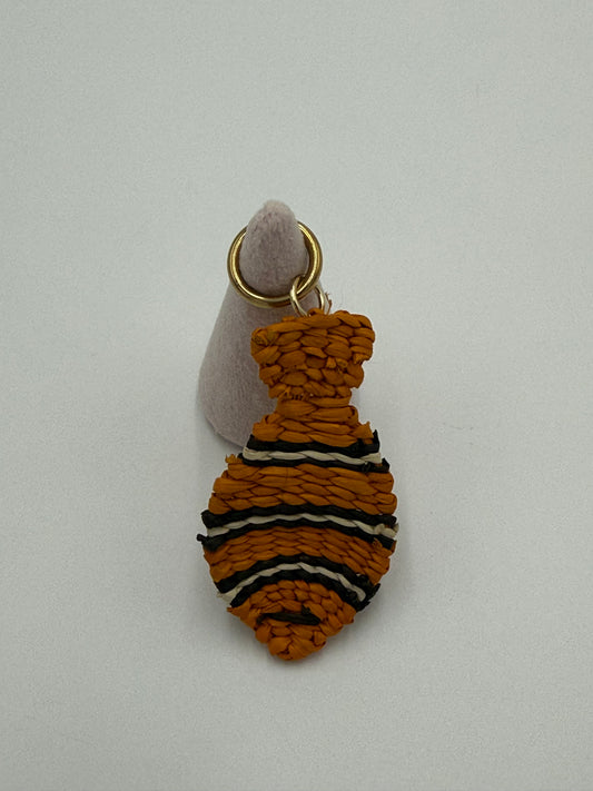 Handgemaakte vis kettingbedel van gevlochten Werregué-palm in oranje met zwarte en witte accenten en bronzen ring verguld met 24 karaat goud
