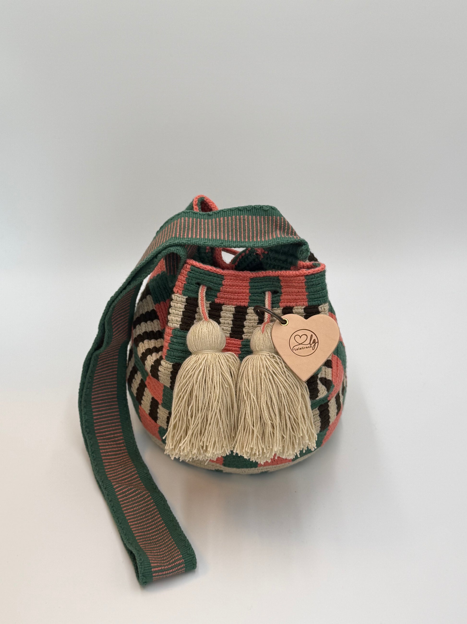 Handgemaakte medium Wayuu tas Eliana met groen-roze patroon en beige kwastjes, gesloten met trekkoord