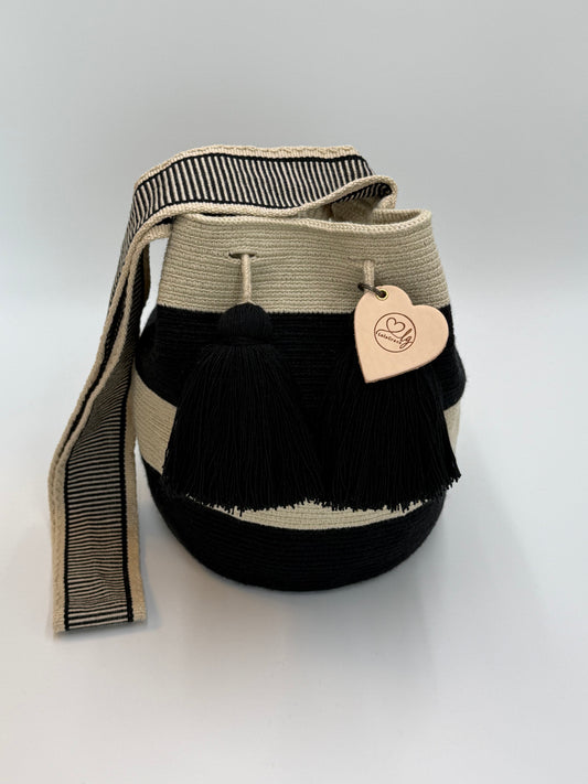 Voorkant van handgemaakte Wayuu tas Isabela Large van LolaGrace in zwart en crème met zwarte kwastjes en geweven schouderband, artisan Wayuu bag uit Colombia.