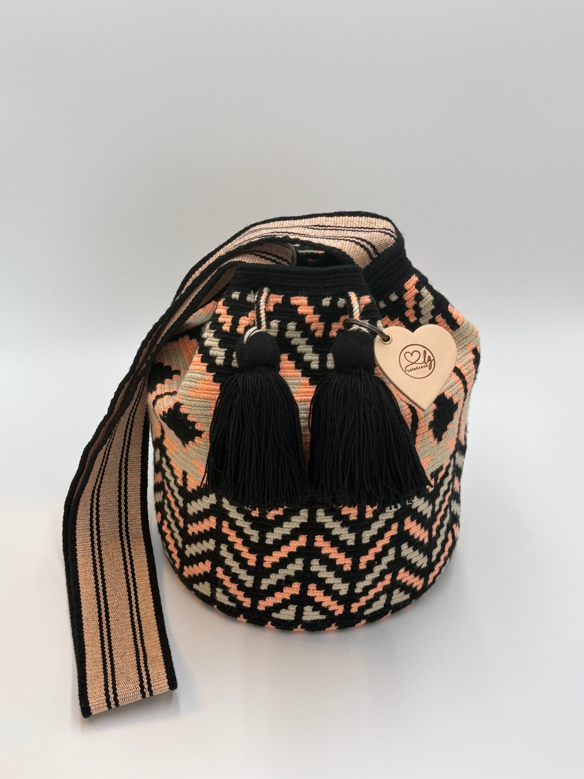Karen Large Wayuu mochila tas van LolaGrace, handgemaakt in Colombia met zwart, perzik en crème geometrisch patroon en zwarte kwasten.
