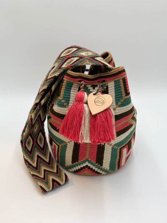 Voorkant van handgemaakte Wayuu tas Luz Elena Large van LolaGrace met geometrisch patroon in groen, crème, bruin en koraalroze en kwastjes in roze en beige.