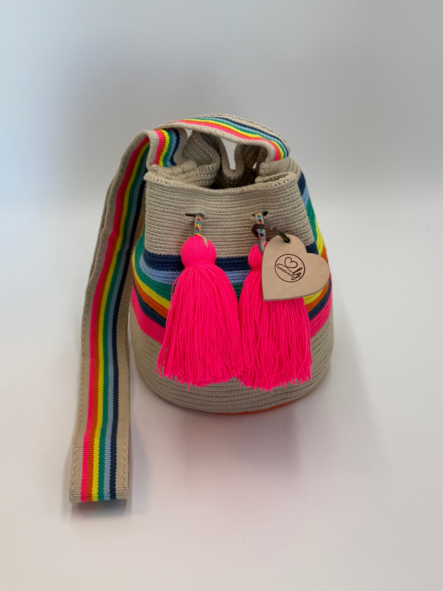 Sara Lucia medium Wayuu tas van LolaGrace handgemaakt in Colombia beige met regenboog schouderband en neon roze kwasten