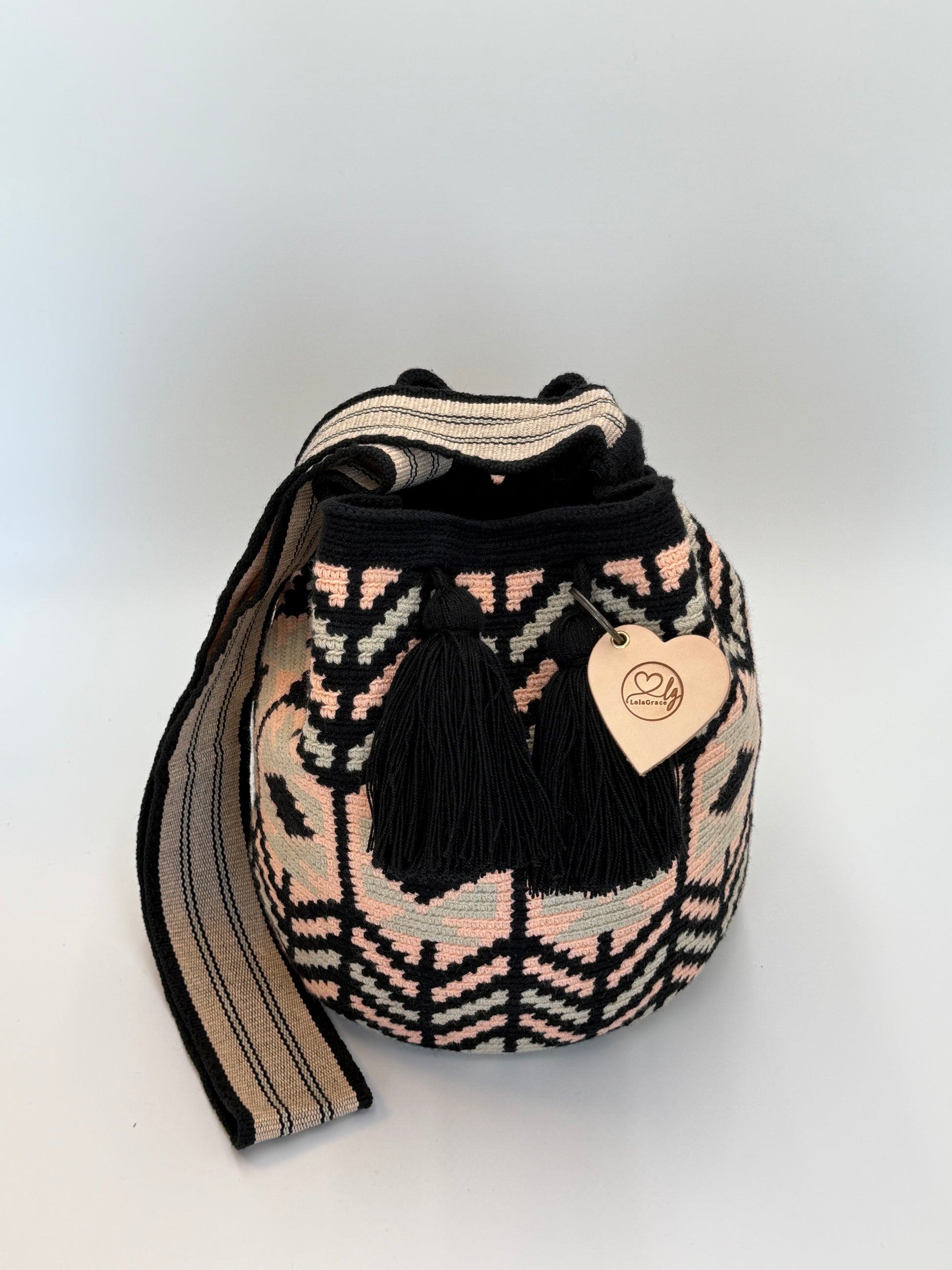 Silvia Large Wayuu mochila tas van LolaGrace, handgemaakt door de Wayuu gemeenschap in La Guajira, Colombia, met zwart, beige en zachtroze geometrisch patroon en zwarte kwasten.
