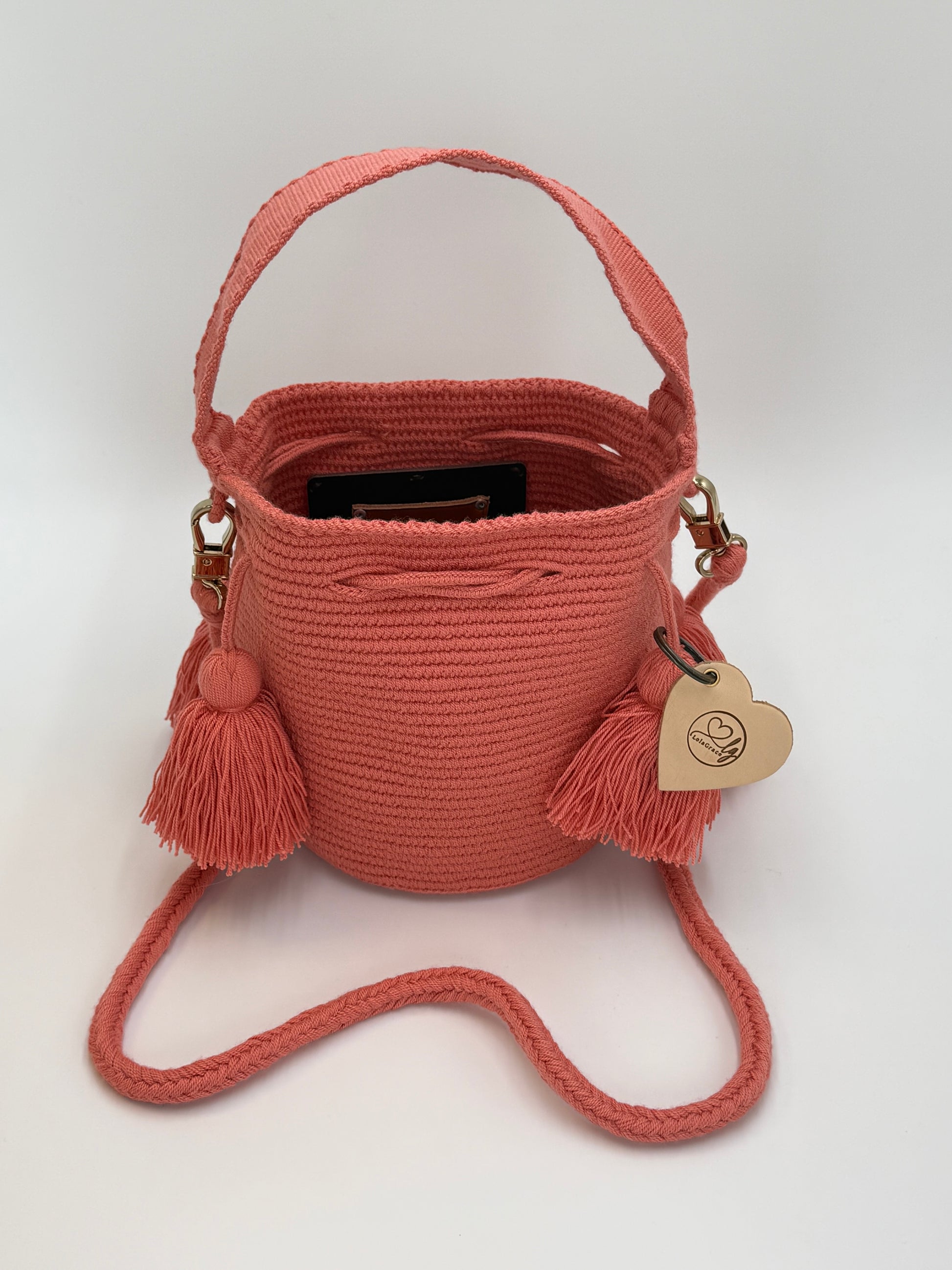 Small Wayuu tas Xiomara in warme koraaltint met handgeweven structuur en speelse kwastdetails